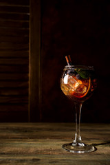 Red berry summer cocktail with brown sugar, blueberries and ice on dark wooden backgorund