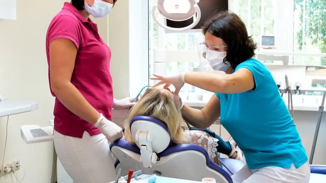 4k footage of female dentist working with patient lying in dental chair