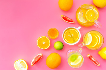 Brew fruit tea. Teacup and teapot near orange, lime, lemon, grapefruit on pink background top view space for text