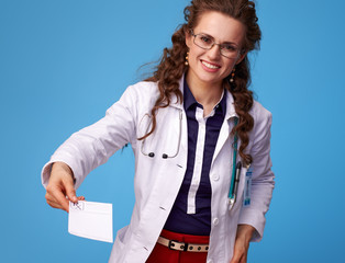 smiling physician woman giving prescription on blue