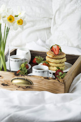 Breakfast in bed: cottage cheese pancakes, coffee and strawberries