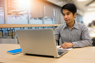Fototapeta premium Happy Business man using laptop at office work space