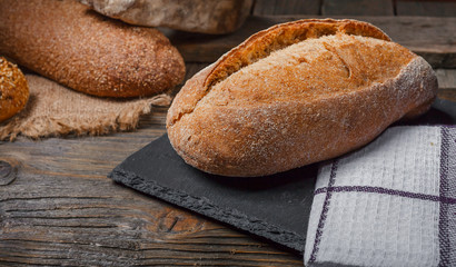 bread in rustic style retro background.Fresh traditional bread on wooden ground with flour in a sack.