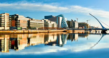 Naklejka premium Nowoczesne budynki i biura nad rzeką Liffey w Dublinie w jasny, słoneczny dzień