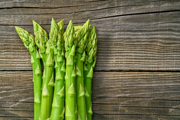 Fresh green shoots of asparagus on a gray wooden background