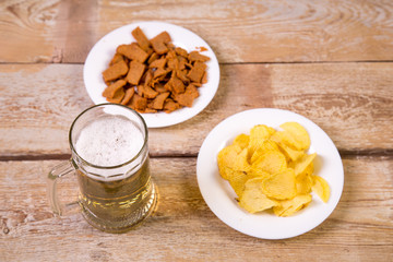 on a wooden table is a mug of foaming beer.
