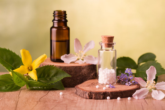 Bottle of homeopathic globules,homeopathic remedies and flowers