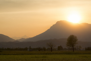 Beautiful sunset in rural area of Meduno, Italy with high mountains on the background.