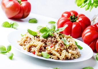 Pasta with meat tomato sauce on a plate, white background, selective focus