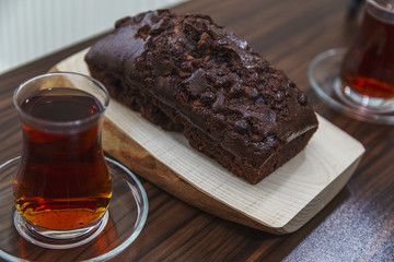 Home made delicious cocoa cake over wooden plate and Turkish tea
