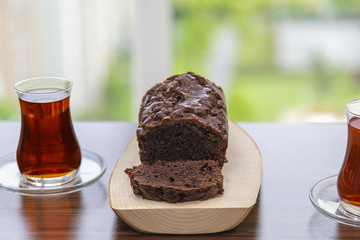 Home made delicious cocoa cake over wooden plate and Turkish tea