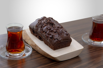 Home made delicious cocoa cake over wooden plate and Turkish tea
