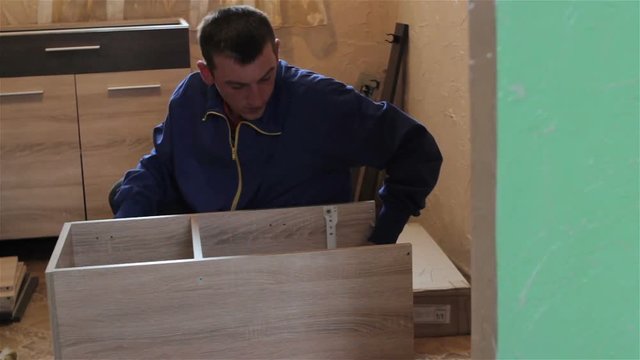Man Assembling Furniture In Workshop,a young student is making furniture Assembling Furniture In Workshop

