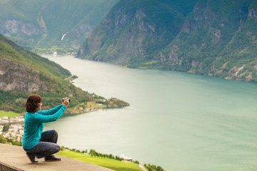 Female tourist taking photo at norwegian fjord