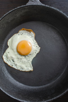 pan with fried eggs on a wooden background