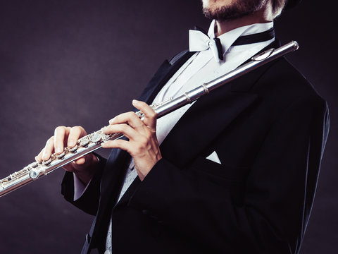 Elegantly dressed musician holding flute