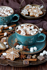 Fototapeta na wymiar Cup of creamy hot chocolate with melted marshmallows and gingerbread cookies for christmas holiday