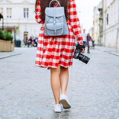 woman walking by city with camera in her hand