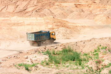 Building construction concept. Truck with architectural materials and equipment riding through sand heaps