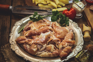 cooking raw chicken with vegetables. on a wooden background.