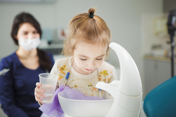 Child rinses out mouth and spit in special sink