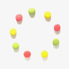 Creative layout made of colorful macaroons on the white background. Food concept. Flat lay, top view, copy space, square 
