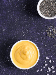 Creamy Cheddar sauce with chia seeds on dark background.Ideas and recipe for healthy diet or vegan food.Homemade Chia Cheeze Sauce for snacks,tacos,nachos,dipping,mac-n-cheese,base for pizza.Copyspace