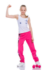 A little girl shows her muscles.
