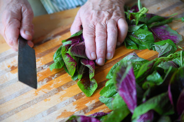 Man prepares fresh amaranth greens
