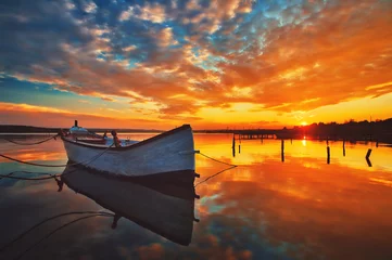 Fotobehang Warm oranje Klein dok en boot aan het meer