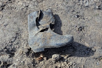 dirty ragged rubber boot on the ground