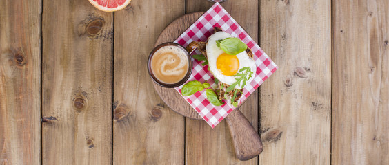 Sandwich of corn bread with egg and ham for breakfast. A healthy and delicious breakfast and coffee. Wooden background. Fitness food, toast. Top view, banner
