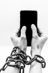 Man in chains holding a smartphone in monochrome