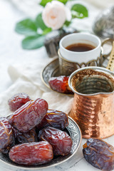 Delicious dates on a bronze plate and black coffee.