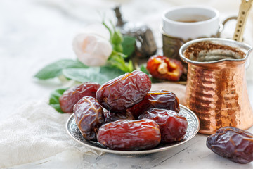 Organic dried dates on a bronze plate. - obrazy, fototapety, plakaty