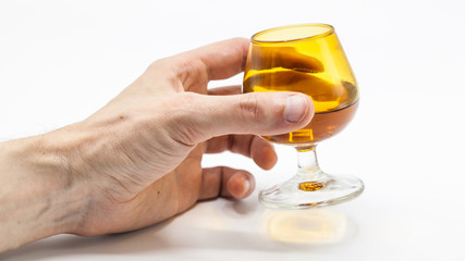 Hand holding glass with alcohol