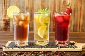 Three glasses of different cold tea drinks black, green with lemon and mint, hibiscus teas. © VictoriaKurylo