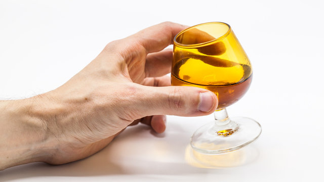 Hand holding glass with alcohol