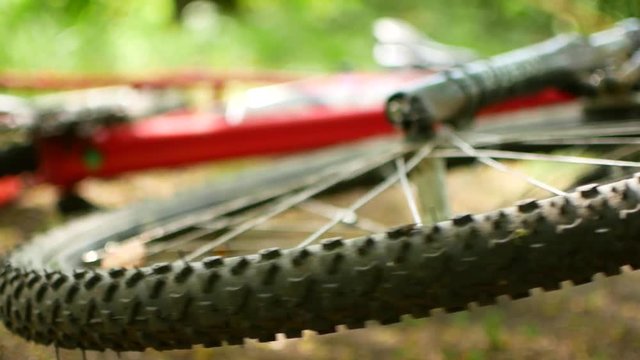 Spoked wheel of an overturned mountain bike. spins freely FullHD video