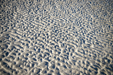 Abstract view of ripple texture left in the sand on a beach at low tide.