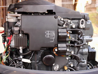 Left side of four-stroke outboard motor with electric starter and ignition coils