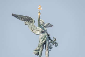 Statue of beautiful angel with wings at the top of column on the Cechuv Most Bridge in Prague,...