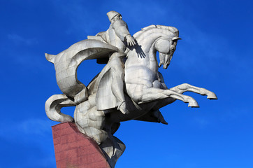 White metal monument mounted on a stone pedestal