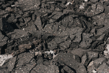 Old cracked asphalt road scrapheap damage on the ground to be recycled.concept for the reduce reuse and recycle.close-up of old cracked asphalt .Select focus. Gray texture background