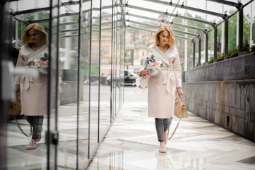 Obraz premium Girl walking on the street holding a beautiful bouquet