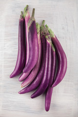 Fresh, beautiful purple violet eggplants decorated on a white wood table, studio shoot can be used as background
