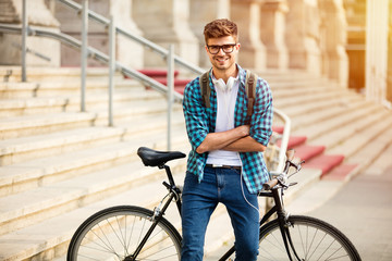 student with bike on the street in front of university