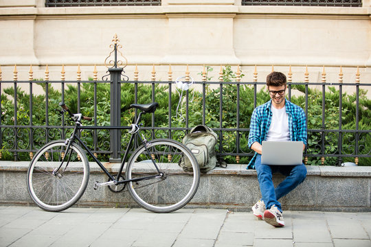 young man working on laptop outside