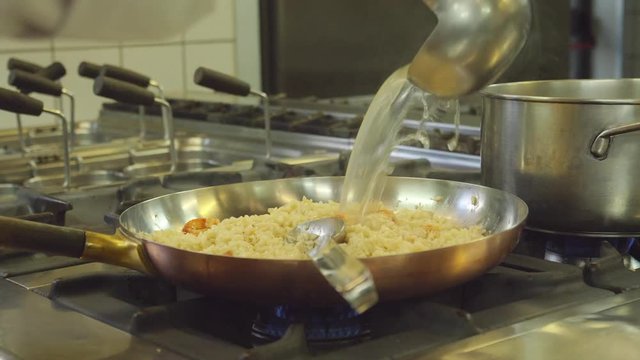 Close up, chef cooks risotto in pan