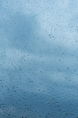Drops of rain on the window glass Shallow DOF. Window after rain. Blue Water background with water drops